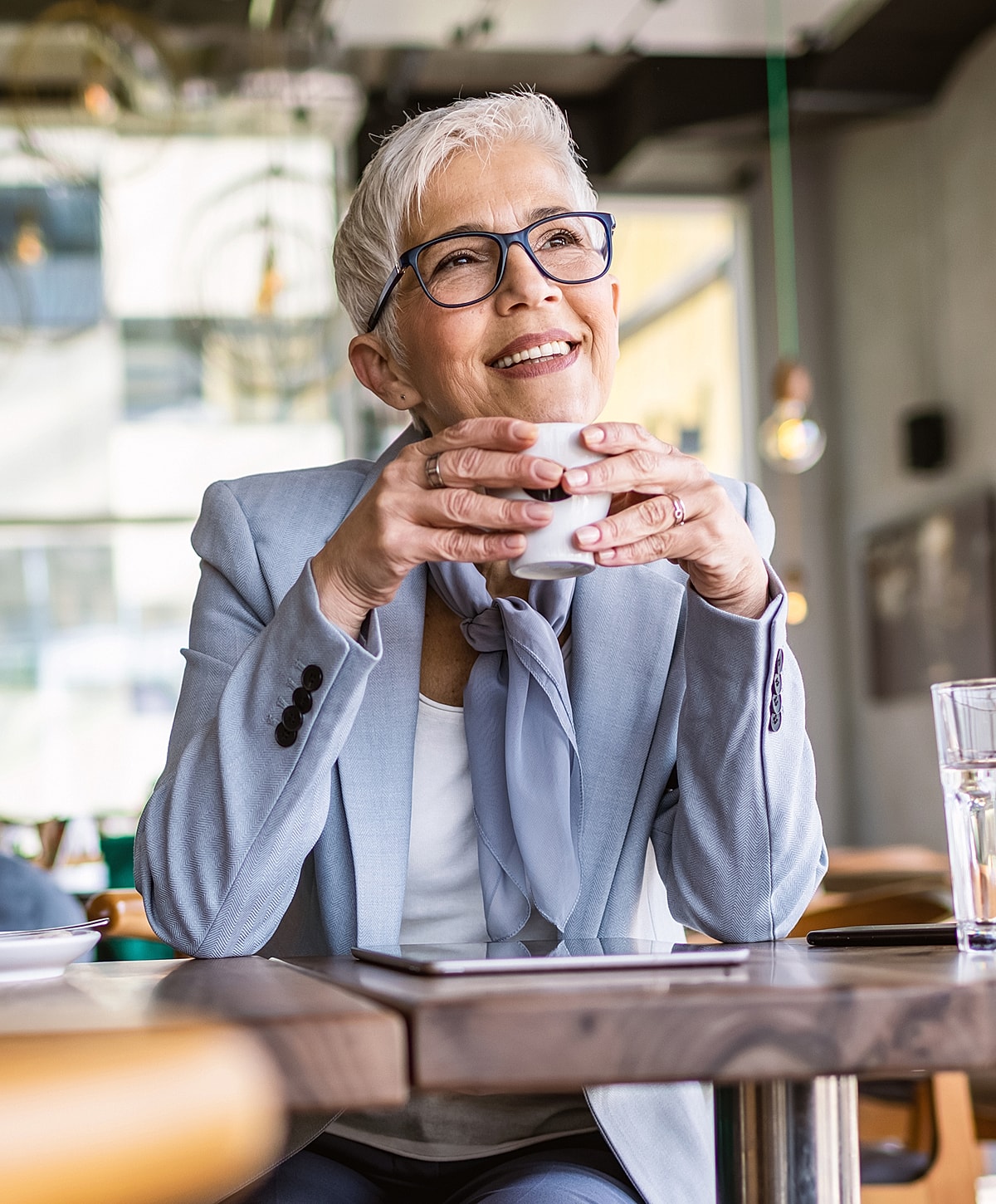 Smiling woman enjoying coffee in a café.