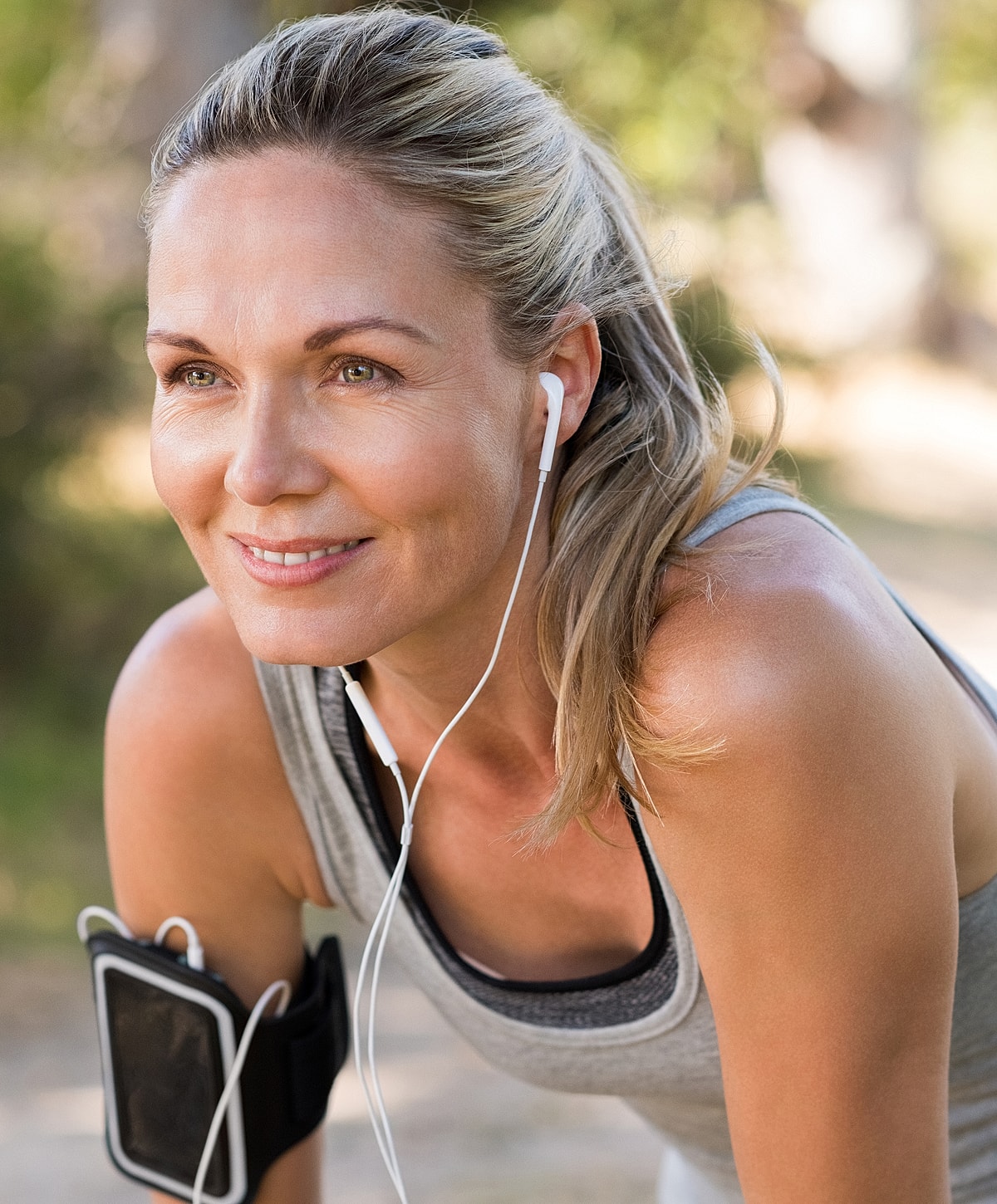 Woman exercising outdoors with headphones on.
