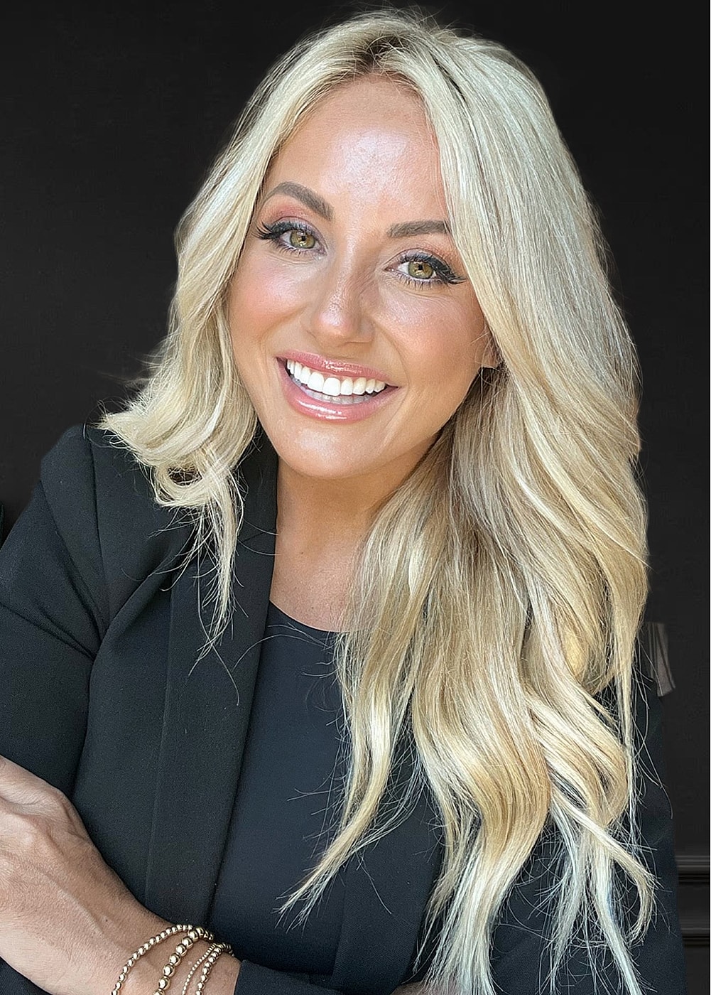 Smiling woman with blonde hair in professional outfit.